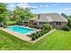 Aerial view of a backyard swimming pool with a slide, lounge chairs, and manicured landscaping at 1682 S Fox Cove Blvd, New Palestine, IN 46163