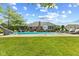Backyard featuring a pristine in-ground pool with a slide, lounge chairs, and manicured landscaping at 1682 S Fox Cove Blvd, New Palestine, IN 46163