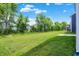 Expansive backyard with lush green grass, mature trees, and a concrete patio perfect for outdoor living at 16929 Sandhurst Pl, Westfield, IN 46074