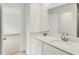 Bright bathroom featuring double sinks with quartz countertops and stainless steel fixtures, adjacent to an open doorway at 16929 Sandhurst Pl, Westfield, IN 46074