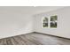 Minimalist bedroom features hardwood floors, white walls, and two sunny windows at 16929 Sandhurst Pl, Westfield, IN 46074
