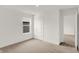 This bedroom features neutral carpet, white walls, a window, and a paneled door at 16929 Sandhurst Pl, Westfield, IN 46074