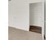 Hallway with white doors and trim contrasted against neutral colored carpet and dark wood floors at 16929 Sandhurst Pl, Westfield, IN 46074