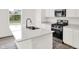 Kitchen island with white countertops, stainless steel sink, and modern fixtures at 16929 Sandhurst Pl, Westfield, IN 46074