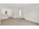 Open-concept living room with white walls, carpeted floors, and a view of the hallway at 16929 Sandhurst Pl, Westfield, IN 46074