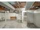 Unfinished basement featuring concrete floor, exposed beams and ductwork, and shelving for storage at 171 Nursery Rd, Anderson, IN 46012