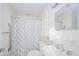 Bright bathroom with neutral fixtures, a shower with tub, storage cabinet and a patterned shower curtain at 171 Nursery Rd, Anderson, IN 46012