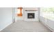 Cozy living room featuring new carpeting, a brick fireplace, and bright natural lighting at 171 Nursery Rd, Anderson, IN 46012