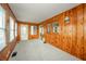 A sunroom lined with wood paneling and multiple windows offer a view of the surrounding landscape at 171 Nursery Rd, Anderson, IN 46012