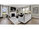 Modern living room with a fireplace, light-colored furniture, a dark accent mirror, and views from the windows at 19838 Moorpark Lndg, Noblesville, IN 46062