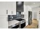 Modern kitchen features stainless steel appliances, black backsplash and white cabinets at 2008 Yandes St, Indianapolis, IN 46202