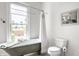 Bright, white bathroom featuring vintage tub, modern toilet and great natural light at 214 E St Joseph St, Indianapolis, IN 46202