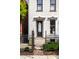 Inviting two-story home with an ornamental fence, front door, and manicured front lawn at 214 E St Joseph St, Indianapolis, IN 46202