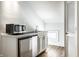 This kitchenette features a sink, stainless steel mini fridge and microwave, complemented by white shaker cabinets at 214 E St Joseph St, Indianapolis, IN 46202