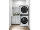 Bright laundry room featuring stacked washer and dryer units, storage cabinets, and modern fixtures at 214 E St Joseph St, Indianapolis, IN 46202