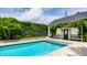 Back exterior of home features a pristine pool with a well-manicured lawn and mature trees at 214 E St Joseph St, Indianapolis, IN 46202