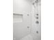 A shower with white tile, shower head and sleek built-in storage at 214 E St Joseph St, Indianapolis, IN 46202