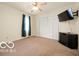 This bedroom includes a ceiling fan, a large closet, and a mounted television at 2410 S Ebright St, Muncie, IN 47302