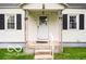 This home features a covered front porch with concrete steps and a white front door at 2410 S Ebright St, Muncie, IN 47302