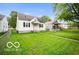 This home has a large front yard with lush green grass and mature trees at 2410 S Ebright St, Muncie, IN 47302