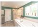 Bathroom with a bathtub, glass-enclosed shower, and natural light at 265 Gathering Ln, Greenwood, IN 46143