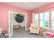 Bright pink bedroom with playful decor, large windows, and doorway to closet at 265 Gathering Ln, Greenwood, IN 46143