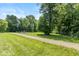 A dog park features lush green grass, walking paths, and mature trees, creating a serene outdoor recreation space at 265 Gathering Ln, Greenwood, IN 46143