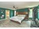 Spacious main bedroom with ensuite bathroom featuring a large bed, stylish decor and hardwood floors at 265 Gathering Ln, Greenwood, IN 46143