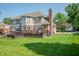 Spacious backyard featuring a two-level deck, lush lawn, and partial brick exterior on a sunny day at 2901 Hazel Foster Dr, Carmel, IN 46033