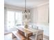 Sunlit dining room features a wooden table, bench, and chairs under a modern chandelier at 2901 Hazel Foster Dr, Carmel, IN 46033