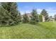 Backyard featuring a well-manicured lawn and mature trees, creating a private oasis at 2920 Bloomsbury S, Greenwood, IN 46143