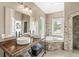 Luxurious bathroom featuring double sinks, a soaking tub, and a walk-in shower with decorative tile at 2920 Bloomsbury S, Greenwood, IN 46143