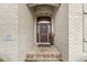 Close-up of a welcoming front door with brick surround, a potted plant, and clear signage at 2920 Bloomsbury S, Greenwood, IN 46143