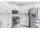 Well-equipped kitchen with stainless steel appliances, white cabinets, and a marble backsplash at 2920 Bloomsbury S, Greenwood, IN 46143