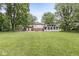 Expansive backyard featuring a patio, an enclosed sunroom, lush lawn, and mature trees offering ample outdoor living space at 3090 N County Road 800 E Rd, Brownsburg, IN 46112