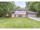Charming home featuring a spacious lawn, a welcoming front porch, and an attached two-car garage at 3090 N County Road 800 E Rd, Brownsburg, IN 46112