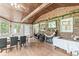 Open sunroom area featuring wood beam ceilings, brick accent wall, fireplace, and access to outdoor views at 3090 N County Road 800 E Rd, Brownsburg, IN 46112