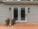 The back porch features double doors with a decorative handle and outdoor lighting with vibrant potted flowers at 3641 Harrison St, Needham, IN 46162