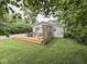 Backyard view highlighting the expansive wooden deck, lush lawn, and surrounding mature trees at 3641 Harrison St, Needham, IN 46162