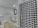 Modern bathroom features a vanity and a shower with a stylish black and white patterned curtain at 3641 Harrison St, Needham, IN 46162