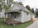 The exterior features a quaint porch and access to a wooden deck, with a well-maintained gravel driveway at 3641 Harrison St, Needham, IN 46162