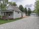 The property showcases a gravel driveway leading to a detached garage and additional parking area at 3641 Harrison St, Needham, IN 46162
