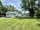Spacious backyard with large shade tree and view of house and storage shed at 3712 S Kealing S Ave, Indianapolis, IN 46237