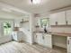 Bright open kitchen with white cabinets, light countertops, subway tile backsplash and modern black fixtures at 3712 S Kealing S Ave, Indianapolis, IN 46237
