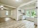 Open kitchen and living area with white cabinets, light countertops, and plenty of natural light from two windows at 3712 S Kealing S Ave, Indianapolis, IN 46237
