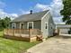 Charming home featuring a spacious front deck, well-maintained siding, and a detached garage at 405 E Cowing Dr, Muncie, IN 47303