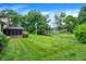 A lush backyard, with mature trees, stretches out next to an enclosed porch on home's exterior at 4070 Serenity Way Ct, Greenwood, IN 46142