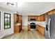 Well-lit kitchen with stainless steel appliances, wood cabinets, and a window view at 4070 Serenity Way Ct, Greenwood, IN 46142