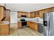 This open kitchen has stainless steel appliances, natural wood cabinets, and hardwood floors at 4070 Serenity Way Ct, Greenwood, IN 46142
