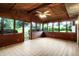 Bright sunroom featuring neutral tile flooring, wood paneled walls and ceiling, with windows overlooking a lawn at 4070 Serenity Way Ct, Greenwood, IN 46142